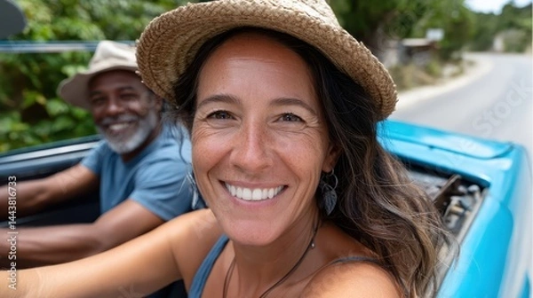 Obraz A joyful woman and a man in a hat share a happy moment in a car, driving together on a sunny day, surrounded by lush greenery reflecting companionship and adventure.
