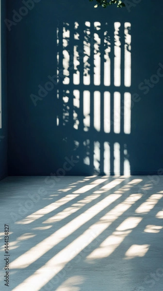 Fototapeta A blue wall with a window and a plant in front of it. The window is open, and the sunlight is shining through the window, creating a shadow on the wall