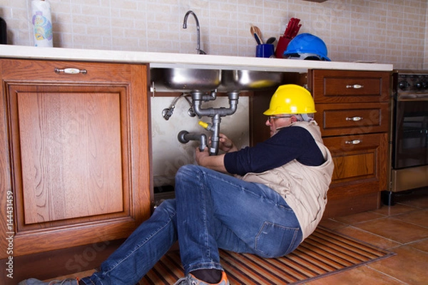 Obraz plumber at work to fix a sink