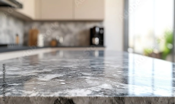 Fototapeta Sleek, modern kitchen countertop with granite surface  Close-up view, blurry background showing cabinets, appliances, and a window