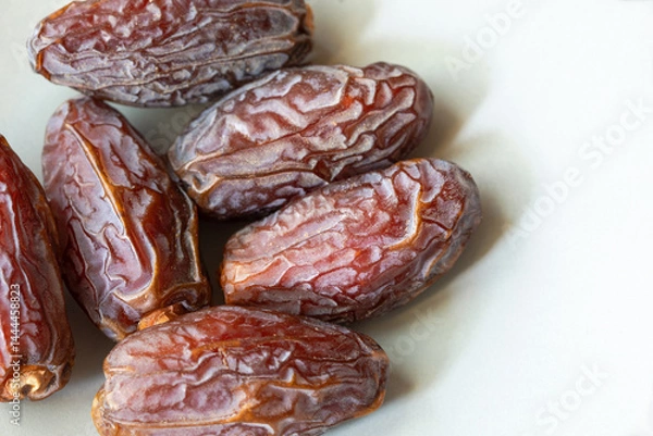 Obraz Close view of several freshly dried dates on the plate with copy space