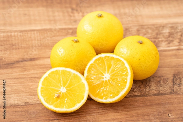 Obraz 木目背景に並ぶ黄色い果実湘南ゴールド