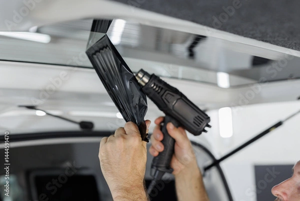 Fototapeta Process remove protective tint film from car. Transparent protection for window vs sun.