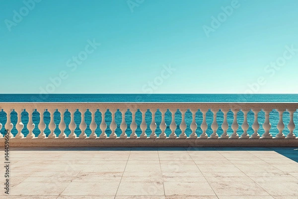 Fototapeta An empty observation deck with a white fence and columns overlooking a calm ocean on a sunny day.