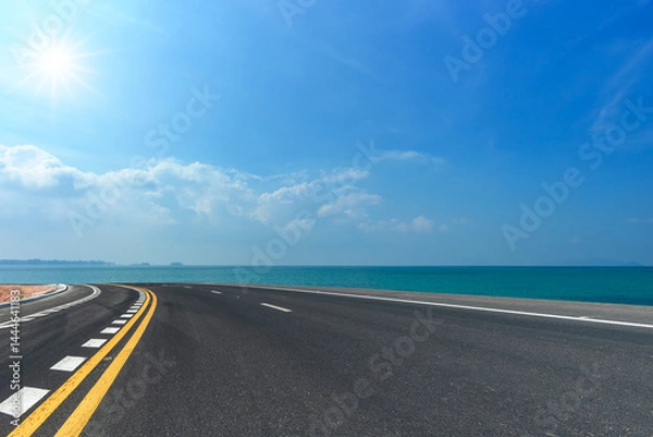 Fototapeta Side view of asphalt road  on sea and beautiful blue sky.