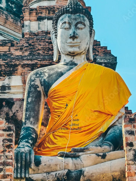 Obraz Close-up view of large Buddha statue draped in yellow robes in Ayutthaya, Thailand.