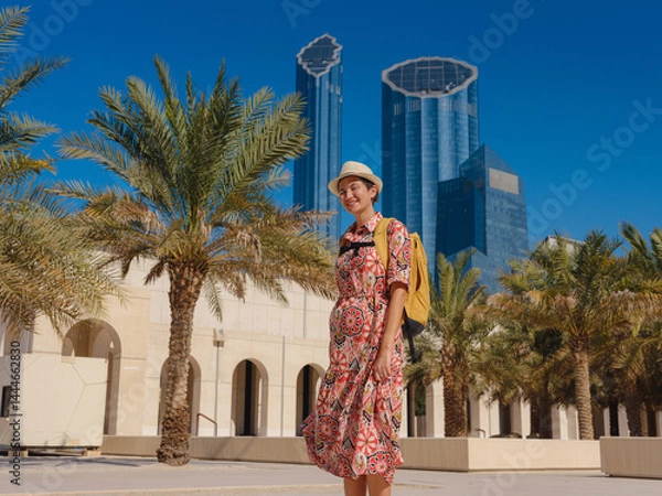 Fototapeta Young woman exploring Qasr Al Hosn Park in Abu Dhabi. Surrounded by lush greenery and historical landmarks, she enjoys the serene atmosphere and Emirati heritage in heart of city.