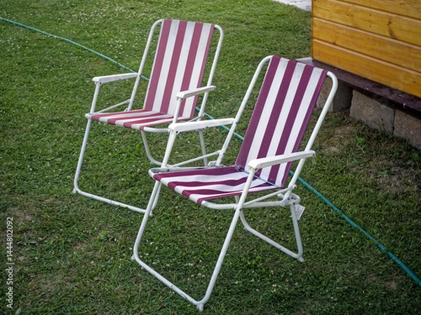 Obraz Old striped folding chairs in a rural garden