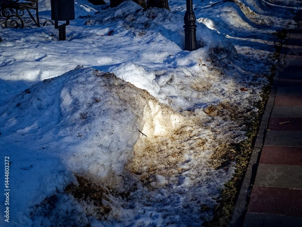Obraz Street lamp pole in a snowdrift of dirty snow