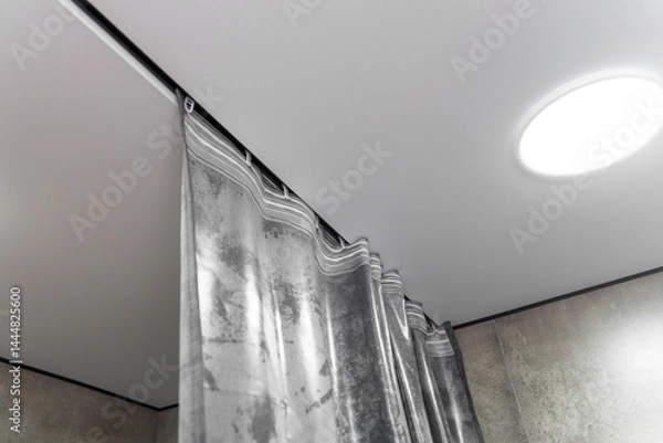Fototapeta Modern gray curtains are hanging from a ceiling track system, adding a touch of elegance and style to the interior design of a contemporary apartment