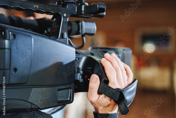 Obraz Filmmaker capturing important moments with professional camera in studio setting