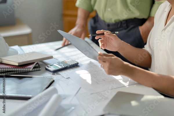 Obraz Two engineer businessman talking and brainstorming to planning about blueprint