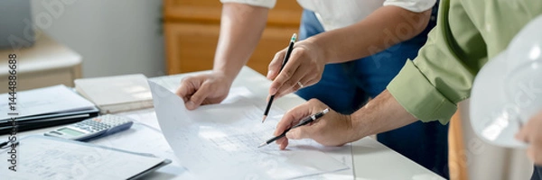 Obraz Two engineer businessman talking and brainstorming to planning about blueprint