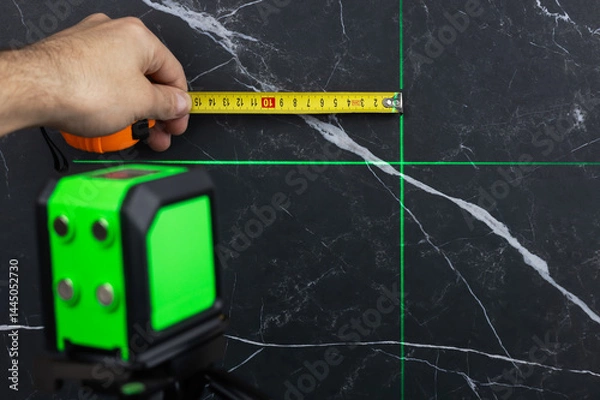 Fototapeta Laser level when building a wall of blocks. laser level for determining precise lines and levels at construction sites