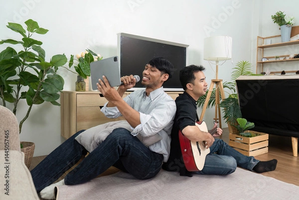 Fototapeta LGBT Friendship and Music. Two men sharing a fun musical experience, enjoying each other's company in a vibrant living space.