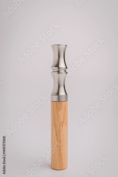 Fototapeta Close-up of a modern duck call made from stainless steel and wood, displayed upright on a white background for product showcase and minimal style..