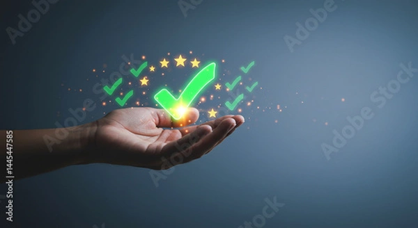 Fototapeta A hand holding a glowing green check mark with stars and smaller check marks floating around it on blue background