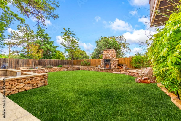Obraz A beautiful backyard featuring a lush green lawn along with a cozy fireplace