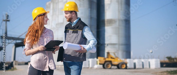 Fototapeta Engineers in front of silo talking and making plans