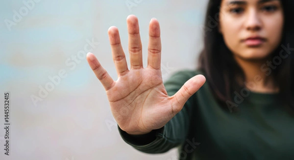 Fototapeta Young latina woman gesturing stop serious expression hand forward outdoors boundary setting. Stop gesture, boundary setting, serious refusal concept.
