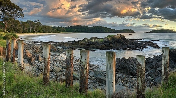 Fototapeta Serene Sunset at Coastal Bay: Panorama of Rocks, Beach, and Ocean