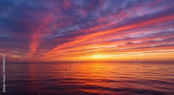 Fototapeta Vibrant sunset over the ocean with colorful clouds reflecting on the water surface at dusk horizon
