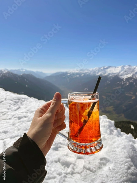 Fototapeta Relishing a Refreshing Drink Amidst the Stunning Mountains on a Bright, Sunny Afternoon