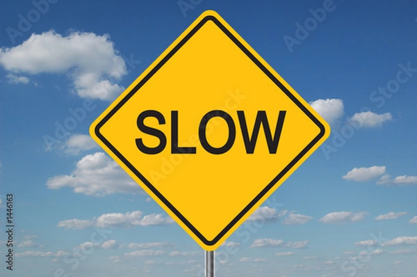 Fototapeta slow traffic sign with clouds