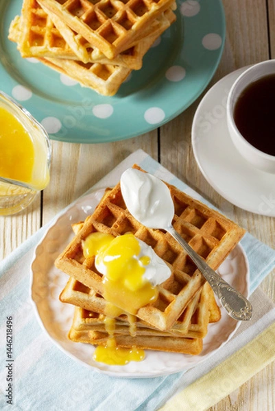 Fototapeta Belgian waffles with cream and lemon curd, served with tea.