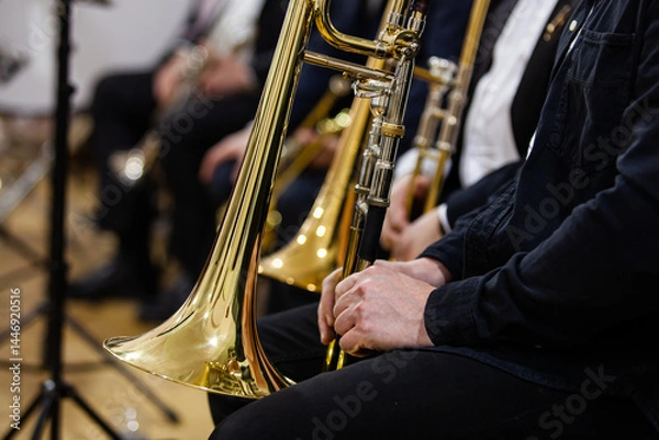 Fototapeta A fragment of a trombone in the hands of a musician in an orchestra