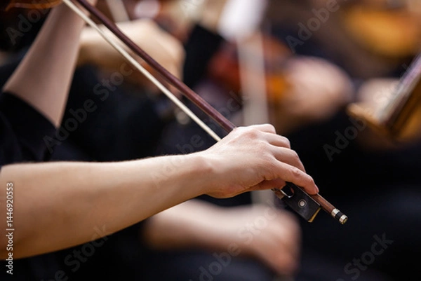 Fototapeta Close-up of a musician's hand playing the violin in an orchestra