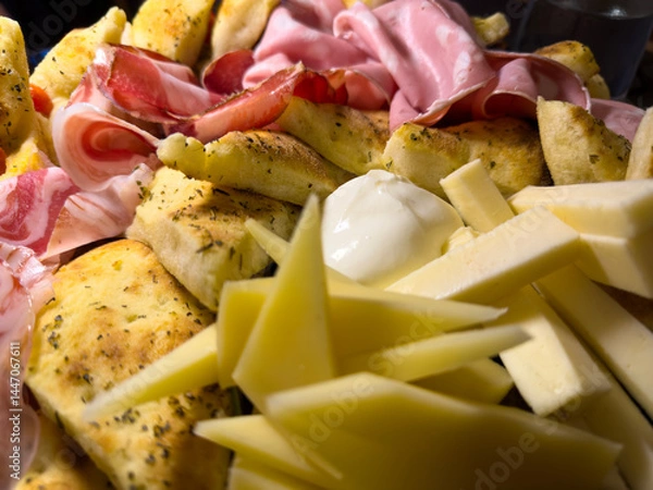 Fototapeta Mix of cheeses and cold cuts with slices of focaccia. Delicious food. Aperitif or starter. Traditional Italian food