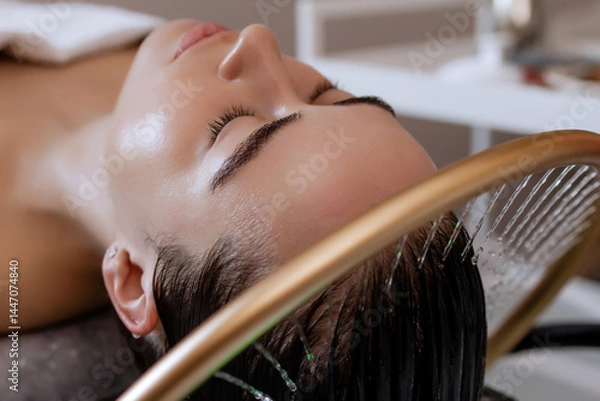 Obraz Close-up of a woman receiving a head massage during a Japanese head spa treatment with water flowing from a special hair washing tool, focusing on the scalp relaxation and beauty therapy