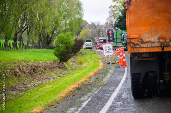 Fototapeta STOP ON RED SIGNAL road sign and traffic cones on the road. Heavy trucks stopped at the red light. North Island. New Zealand.