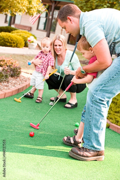 Obraz Golf: Dad Helps Little Boy Learn To Mini-Golf