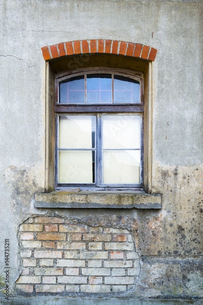 Fototapeta Textured window in an old house. Part of the wall with brickwork.