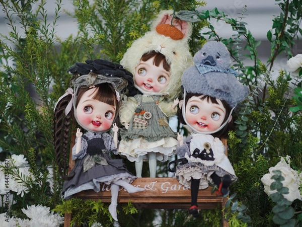 Fototapeta Cute dolls. Three happy girl group dressed in animal theme including rabbit and duck. Vintage dolls are on display at the doll weekend market fair. Soft focus on the left girl's right eye.