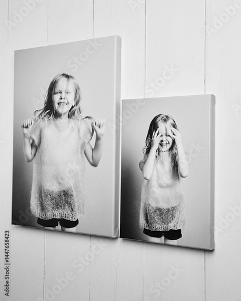 Fototapeta Two black and white canvas prints of a joyful child in different sizes, stretched on wooden stretcher bars with gallery wrapping. Elegant wall decor with high-quality texture