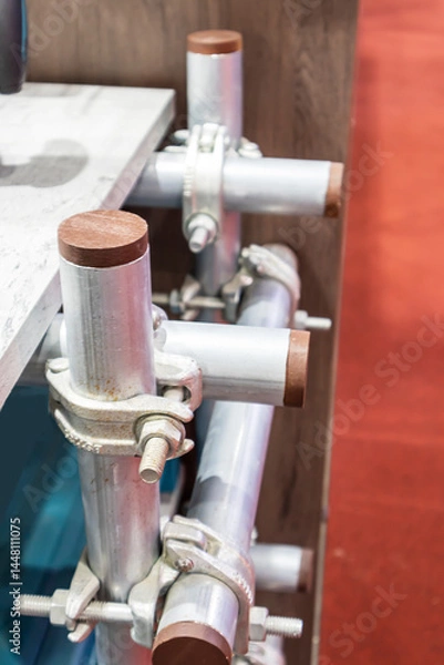 Fototapeta Focus on connecting steel scaffolding structures with steel installation equipment