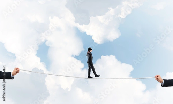 Fototapeta Business concept of risk support and assistance with man balancing on rope