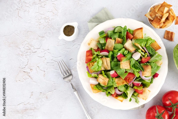 Obraz Lebanese fattoush salad with fresh vegetables, romaine lettuce and pita bread on white background. Top view. Copy space.