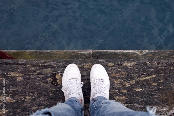 Obraz Person standing on wooden pier, top view above water