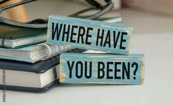 Fototapeta A sign that says Where have you Been is on top of a stack of books