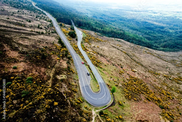 Fototapeta  Aerial view of The Vee Pass winding through the Knockmealdown Mountains, showcasing stunning Irish landscape, vibrant greenery, and dramatic elevation in County Tipperary, Ireland.