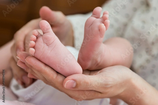 Obraz Parent hands gently holding baby feet from below