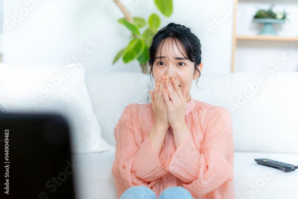 Fototapeta リビングでテレビを見る若い女性