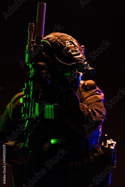 Obraz Tactical operator in night vision equipment lit with green and blue lighting
