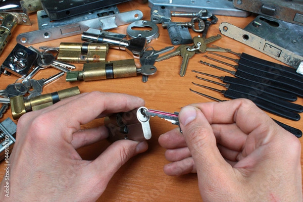 Fototapeta Locksmith inserts key in cylinder lock