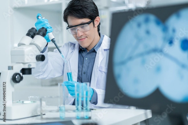 Fototapeta Asian Researcher using a microscope in the clinical lab.male Researcher working in the clinical laboratory,Medical or scientific researcher or Asian man doctor looking at professional microscope.