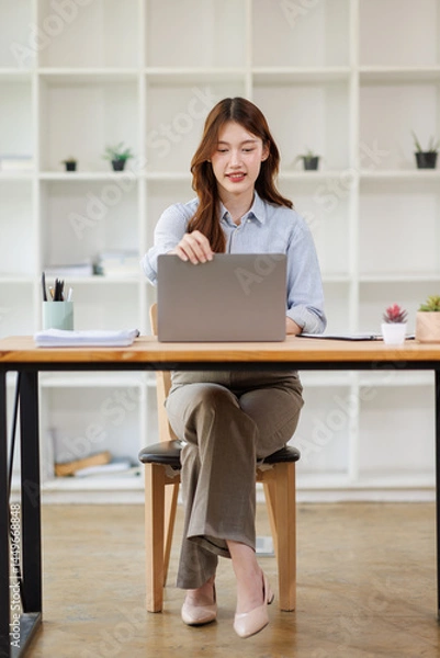Fototapeta Portrait of young attractive positive lady sit chair use phone wireless netbook telephone write typing modern office indoors
